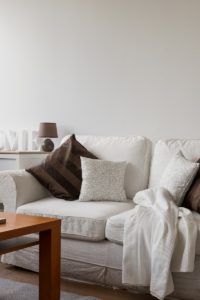 A cozy night on a white couch with throw cushions.